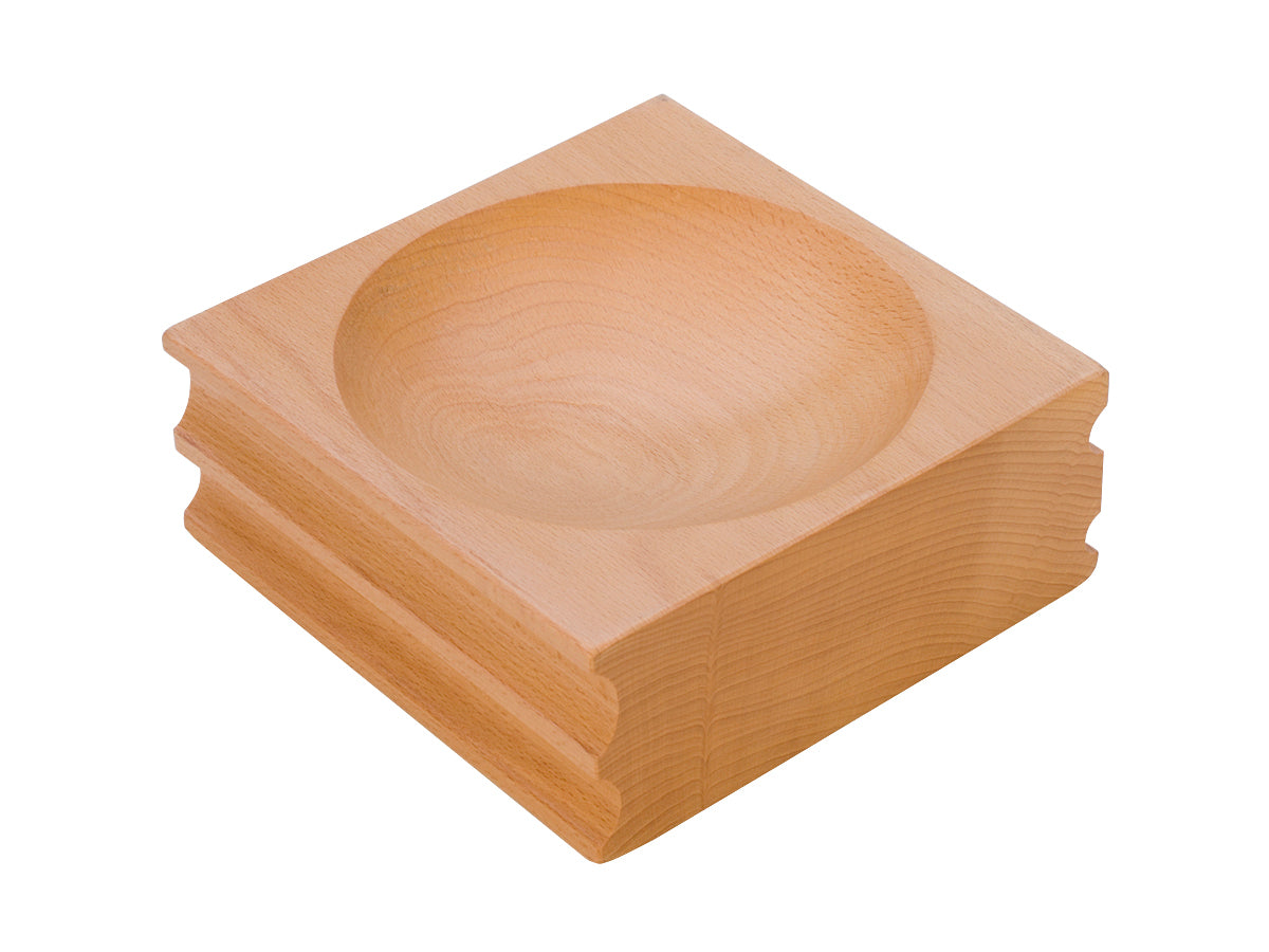 Large shaping block made of rosewood with one round depression and u-channel grooves for metal and woodworking tasks