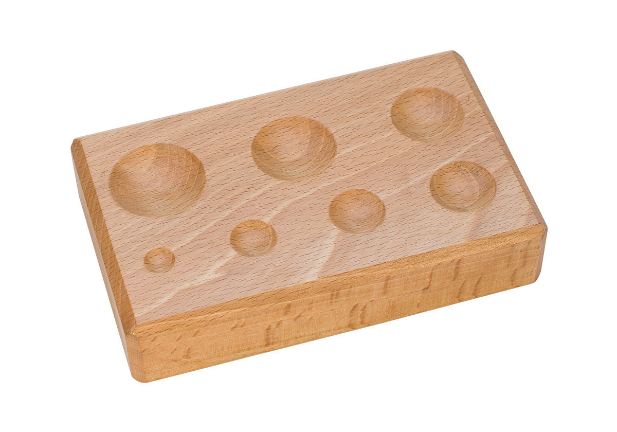 Wooden forming block with seven round depressions for woodworking and crafting tasks