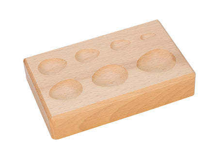 Wooden forming block with seven teardrop depressions for shaping leather, wax, and clay