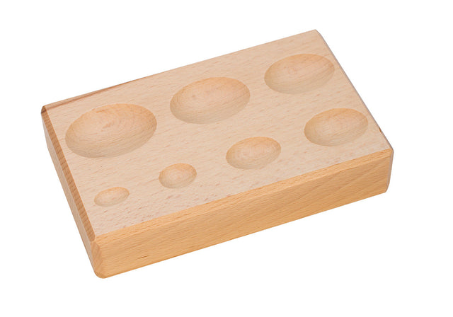 Wooden forming block with seven oval depressions for shaping and molding crafts and woodworking projects